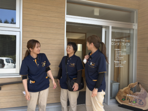 入口の前で笑顔のMさんとスタッフ2人