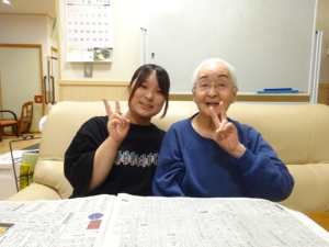 利用者の方とピースをするIさんの画像