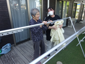 利用者の方と一緒に洗濯物を干すIさんの画像