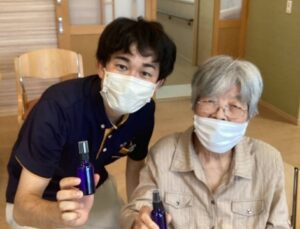 利用者の方とスプレーボトルを持っているSさんの画像