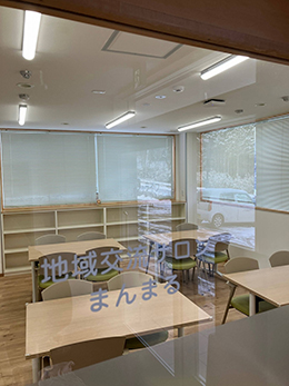 室内のガラスに地域交流サロンまんまるのシールが貼られている画像