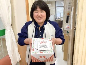 誕生日ケーキの箱をもつ女性
